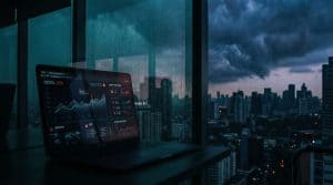 A laptop displaying prediction market trading odds reflected in a window overlooking a city skyline under stormy skies