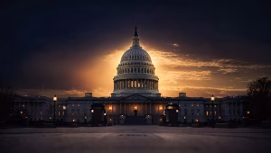 US Capitol dome silhouetted against a deep navy dusk sky with warm amber backlighting and dramatic high-contrast shadows